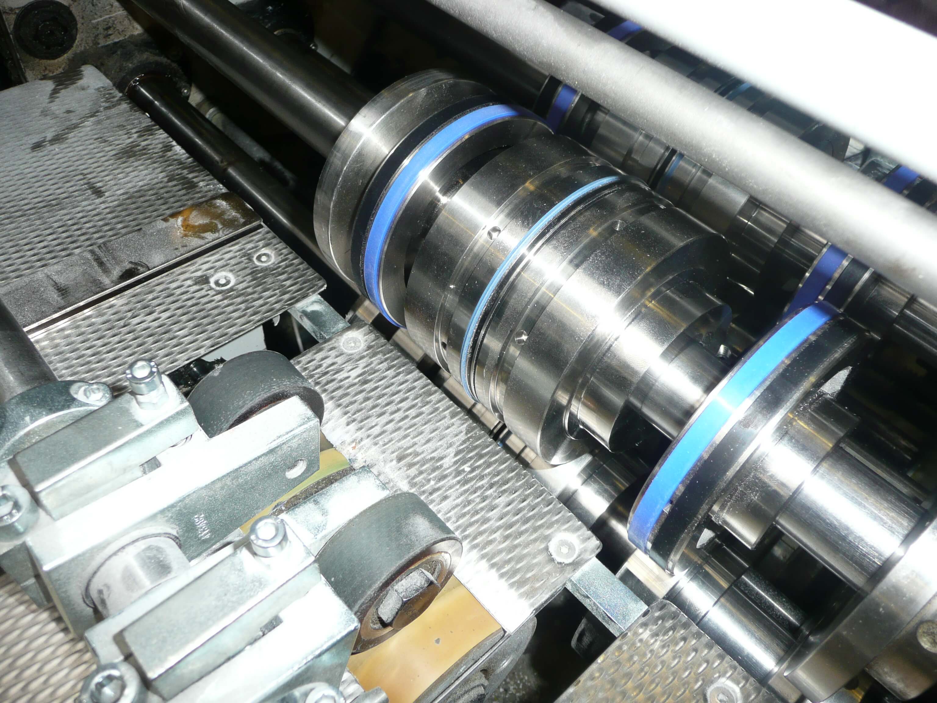Steel creasing tools mounted on folding machine shaft between rollers